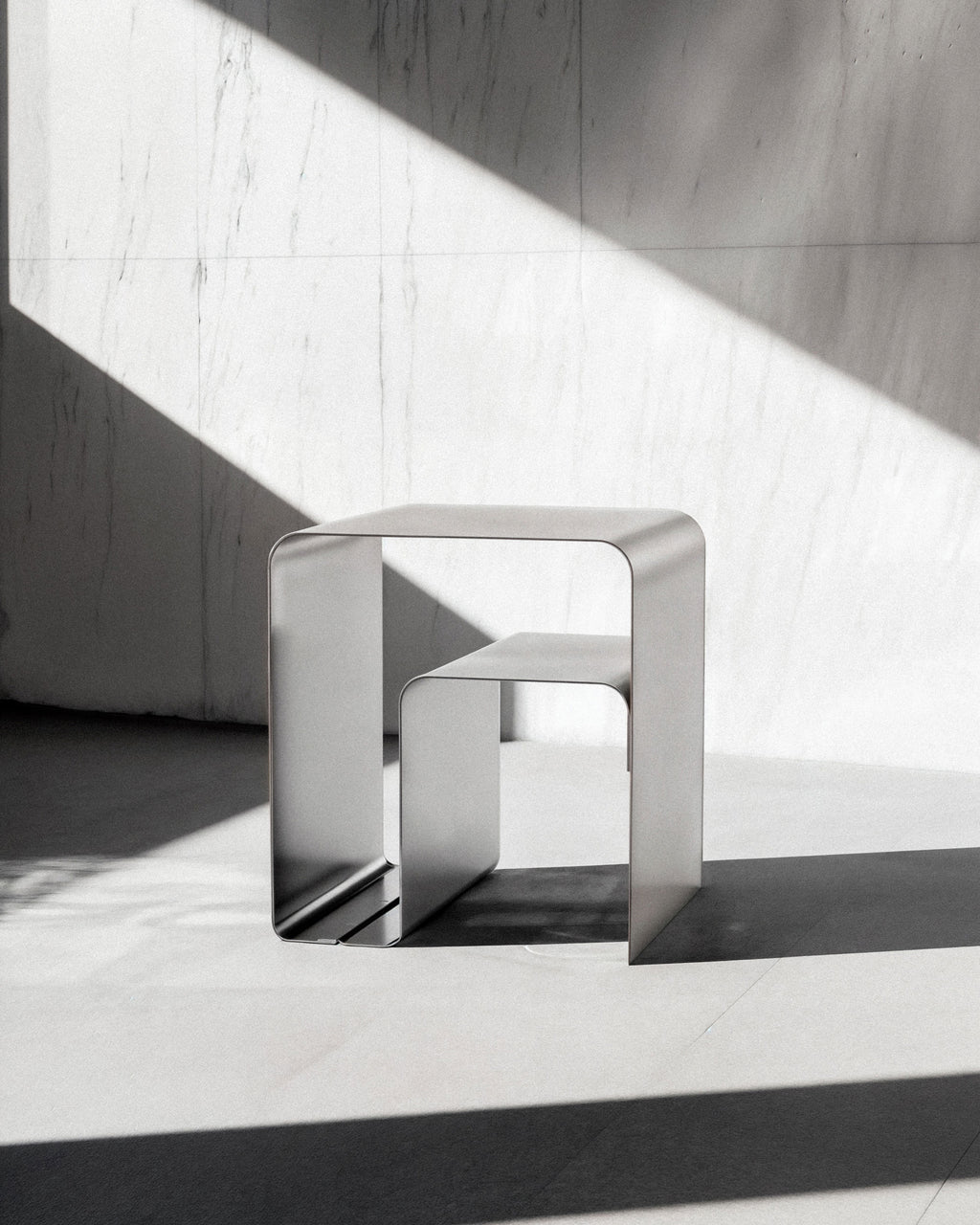 Sidebord i børstet aluminium – tidløst alternativ til hvide og sorte sideborde. Design sidebord i børstet metal fra Rau Studio med integreret hylde.